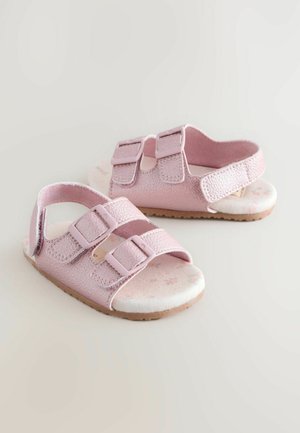 Sandales roses avec doubles sangles Velcro, dessus synthétique texturé, semelle intérieure à motif floral et semelle en caoutchouc souple.