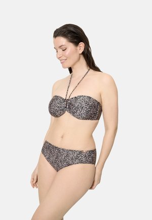 Mujer sonriente con el cabello mojado, vistiendo un bikini sin tirantes con estampado en blanco y negro y una tira tipo halter alrededor del cuello, sobre un fondo claro y liso.