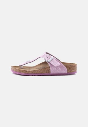 Pink glitrende tanga-sandal med justerbar spænde, formet korkfodbed og lilla gummisål på hvid baggrund.