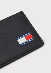 Σακούλα από navy δέρμα με υφή, ραφή στην άκρη και ένα έντονο μπλε, κόκκινο και λευκό ορθογώνιο λογότυπο Tommy Jeans.