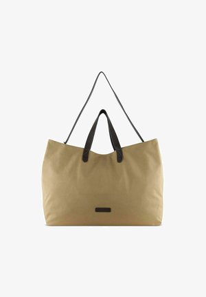 Sac fourre-tout en toile beige avec poignées en cuir noir ; forme spacieuse et rectangulaire ; design minimaliste avec un petit patch logo.