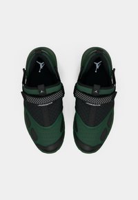 Groene en zwarte sportschoenen met een mesh bovenwerk, textuuraccenten en een centrale band. Heeft een prominent logo op de tong.