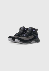 Black and gray high-top hiking shoes with purple accents, thick tread soles, and lace-up closures on a white background.