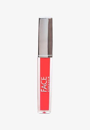 Gloss à lèvres transparent dans un tube transparent avec un capuchon rectangulaire en argent. Contient une formule rouge vif et arbore la marque "FACE STOCKHOLM".