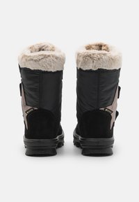 Svarta och bruna vattentäta stövlar med en krage av konstfuskpäls, strukturerade mockadetaljer och en gummisula. Har justerbara remmar på sidorna.