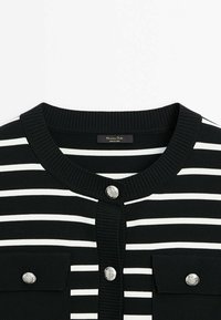 Cardigan rayé horizontal noir et blanc avec col rond côtelé et boutons embossés argentés à l'avant et sur les poches.