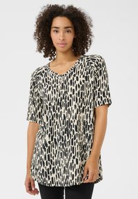 Top a manica corta con scollo a V in crema con stampa astratta nera. Vestibilità rilassata, tessuto morbido e orlo arrotondato. Adatto per un look informale.