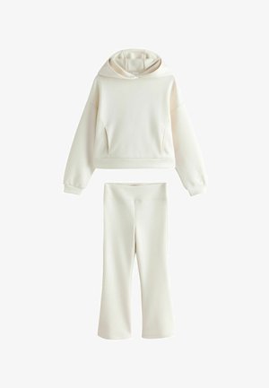 Crème kleurige tweedelige set met een cropped hooded sweatshirt en wijde broekspijpen, weergegeven op een witte achtergrond.