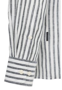 Camicia a maniche lunghe a righe in bianco e navy. Presenta un polsino con bottone e una texture intrecciata con righe orizzontali in contrasto.