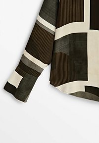 Chemise à manches longues avec un motif géométrique composé de blocs marron foncé, noir, gris et blanc cassé et de fines rayures verticales.