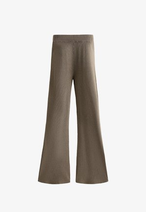 Pantaloni a gamba larga a costine in verde oliva, dotati di un elastico in vita. Il tessuto ha una consistenza morbida e una vestibilità ampia e rilassata.