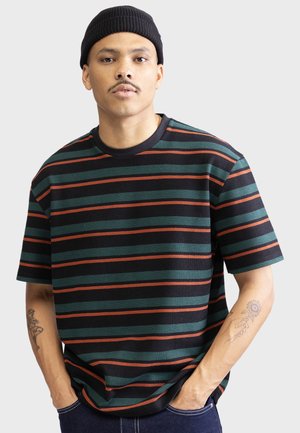 T-shirt rayé à manches courtes, avec des bandes vertes, rouges et noires ; fabriqué en tissu texturé avec un col rond.