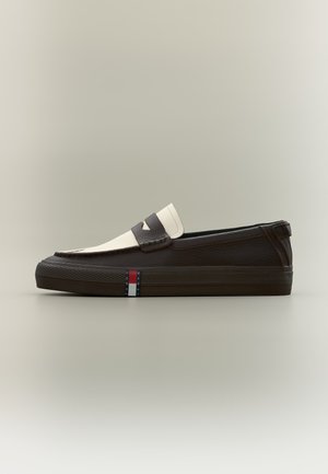 Δίχρωνος sneaker τύπου μοκασίνι από καφέ και εκρού δέρμα με επίπεδη καουτσούκ σόλα και μικρή σημαία Tommy Jeans στο πλάι.