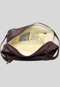 Borsa in pelle borgogna, di dimensioni medie, con chiusura a zip, esterno liscio, interno crema con testo stampato. Cinghia regolabile per il trasporto.