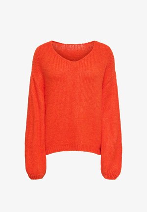 Oranžinis megztinis su V formos iškirpte, ilgomis šiek tiek pūstomis rankovėmis. Pagamintas iš storos mezgimo medžiagos, su laisvu siluetu ir ribotais rankogaliais.