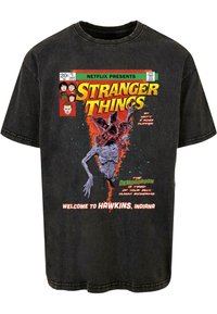 Black cotton T-shirt featuring a detailed graphic print of the Demogorgon, with vibrant red and green text, styled like a comic book cover.