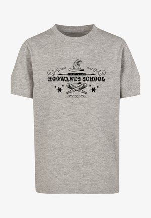 Maglietta grigia con grafica "Hogwarts School", abbinata a pantaloni cargo verde oliva con multiple tasche e sneakers bianche con suola texturizzata.