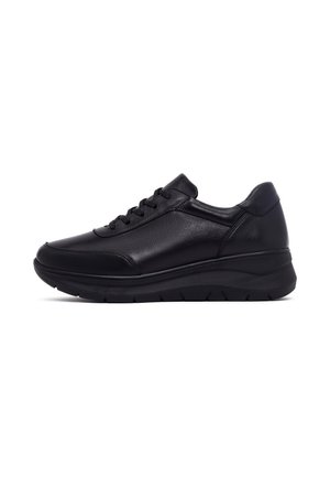 Zapatilla deportiva negra de cuero con suela gruesa y cordones en la parte delantera, vista de lado sobre un fondo blanco.