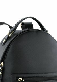 Mochila negra con forma redondeada, hecha de material texturizado, que presenta herrajes dorados, un asa superior y un bolsillo frontal con cremallera.