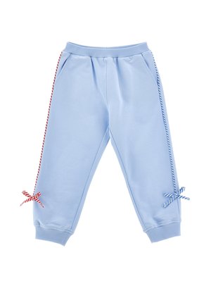 Pantaloni copii albastru deschis cu talie elastică, buzunare laterale, panglici dungi roșii și albastre care coboară pe picioare, legate în fundițe aproape de manșete.
