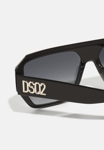 Melnas saulesbrilles ar leņķainu dizainu, tumšiem stikliem un zelta "DS02" logo akcentu sānos. Gluds plastmasas materiāls ar spīdīgu apdari.