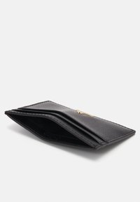 Black leather wallet with a textured finish, featuring multiple card slots and a gold logo accent. Slim, angular design with a matte interior.