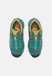 Zapatillas de senderismo turquesa con acentos rojos y amarillos, parte superior de malla, suela de goma texturizada y diseño de cordones único.