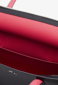 Borsa a tracolla in pelle nera textured con interno in nylon rosa. Presenta una zip argentata e dettagli rosa sulle maniglie.
