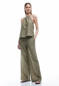 Olijfgroene, lichtgewicht stoffen twee-delig set bestaande uit een haltertop en wijdvallende broek met een elastische trekkoord taille en zakken.