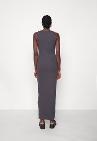 Abito maxi senza maniche grigio realizzato in un tessuto morbido e elasticizzato, con una silhouette aderente che arriva alla caviglia, texture liscia e design minimale.