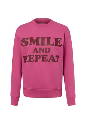 Roze crewneck trui met bruine tekst "SMILE AND REPEAT" aan de voorkant, lange mouwen en geribde boorden aan mouwen en zoom.