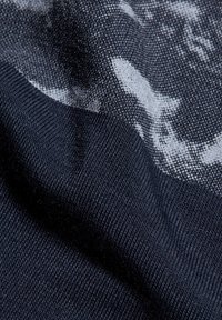 Gestructureerde stof in donker marineblauw met een subtiel lichtgrijs patroon. Het materiaal toont een combinatie van gladde en ribbelige texturen. Close-up weergave.