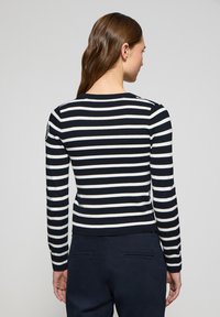 Randig stickad tröja i marinblått och vitt, med långa ärmar och rund hals. Ribbad mudd och nederkant med en logotypapplikation på axeln.