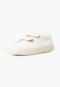Chaussure en toile blanche avec deux bandes Velcro, bout arrondi et semelle en caoutchouc texturée. Design léger avec un tissu doux et des détails de couture minimaux.