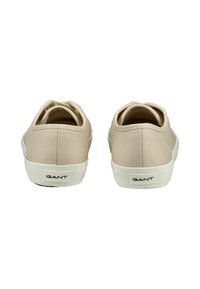 Sneaker in tela beige con punta rotonda, suola in gomma bianca e logo GANT sul tallone. Texture liscia con design semplice.