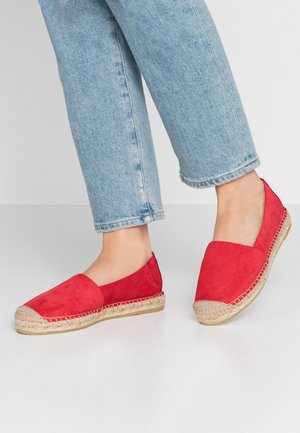 Espadrilles en daim rouge avec une semelle plate en jute et un bout rond. Présentent un design à enfiler et des côtés découpés, associées à un denim clair.