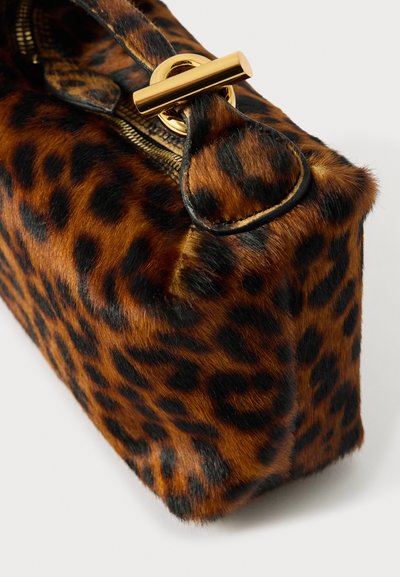 Torba s leopard uzorkom s teksturiranim umjetnim krznom, zlatnim dodacima i zatvaranjem na munju, koja ima zaobljen oblik i čvrstu konstrukciju.