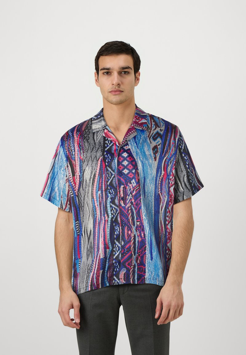 Short-sleeve shirt featuring a vibrant, multicolored abstract pattern with blues, pinks, and black. Lightweight, casual fabric with a collared neckline.