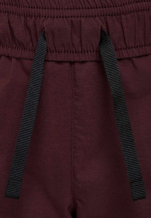 Un pantalon de survêtement bourgogne avec une taille élastique, des cordons de serrage noirs réglables, une texture lisse et des détails de couture subtils.