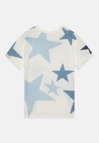 Kortärmad t-shirt i off-white bomull med stora blå stjärnor i varierande nyanser. Rundkrage med mjuk textur och standardpassform.
