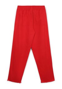 Rote Baumwollhosen mit einem elastischen Bund, ausgestattet mit zwei Gesäßtaschen und einem leicht ausgefransten Saum an den Knöcheln.