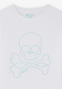T-shirt bianco con una grafica di teschio e ossa incrociate di colore azzurro chiaro. Tessuto in cotone con scollatura rotonda e texture liscia. Nome del marchio in fondo.