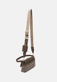 Hnědá kabelka s texturovaným povrchem, která disponuje opakujícím se vzorem loga, nastavitelným popruhem a malou připevn�ěnou peněženkou.