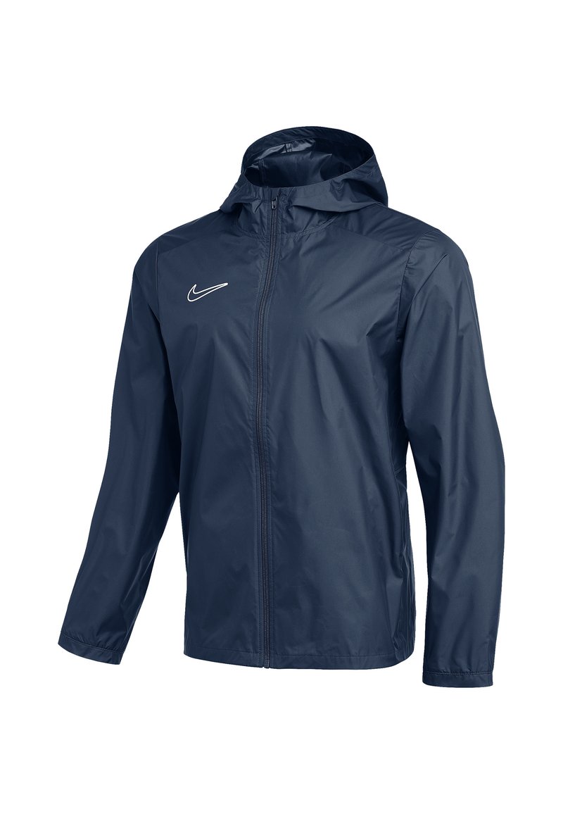 Marineblauwe Nike-jas gemaakt van lichtgewicht, waterafstotende stof, met een volledige ritssluiting en capuchon, voorzien van een klein wit logo op de borst.