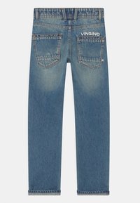 Siniset farkut, joissa on takataskut, käännetyt lahkeet ja "VINGINO" -logo brodeerattu oikean taskun ylle.