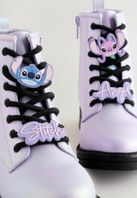 Lyslilla støvler med sorte snørebånd har plastmærker af figurerne Stitch og Angel. Glat tekstur med en chunky sort sål.