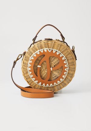 Sac en osier tressé rond en osier naturel avec un accent en cuir marron comportant une découpe circulaire et des coutures crème ; comprend une sangle marron.