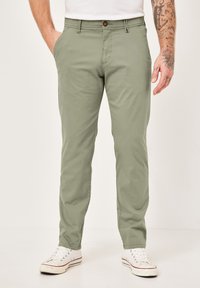 Hellgrüne Baumwollhose mit geradem Schnitt, ausgestattet mit einem Reißverschluss und Knopfverschluss, seitlichen Taschen und einer glatten, matten Oberfläche.