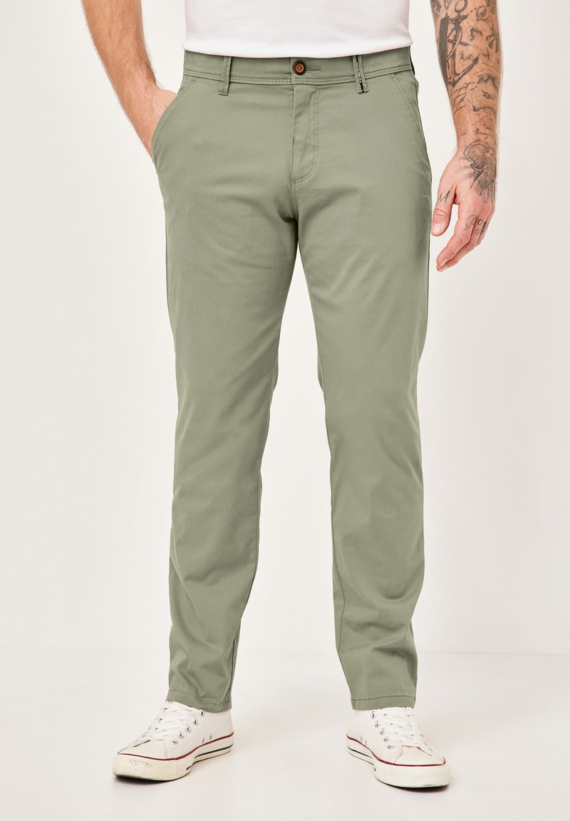 Hellgrüne Baumwollhose mit geradem Schnitt, ausgestattet mit einem Reißverschluss und Knopfverschluss, seitlichen Taschen und einer glatten, matten Oberfläche.