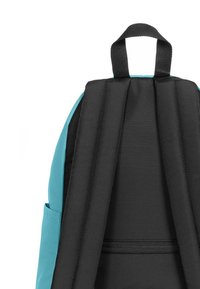 Batoh s tyrkysovým vnějším povrchem a černými polstrovanými popruhy. Obsahuje postranní kapsy, kapsu na zip a texturovanou tkaninu pro zvýšení odolnosti.